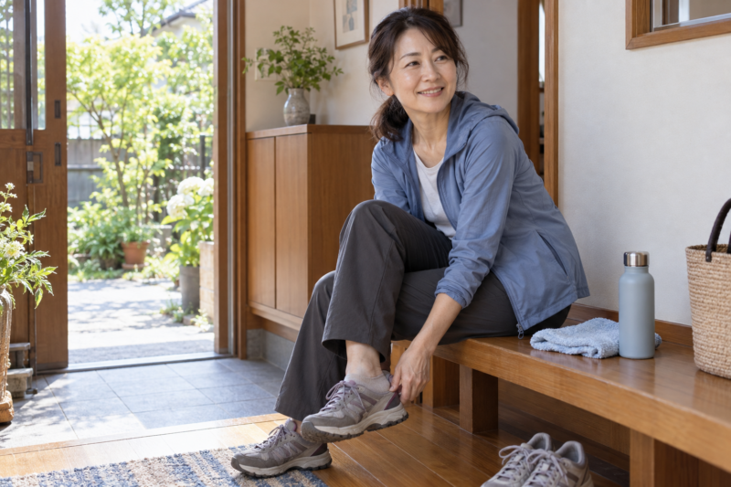 散歩から戻り、玄関のベンチで靴を脱ぐ40代くらいの女性
