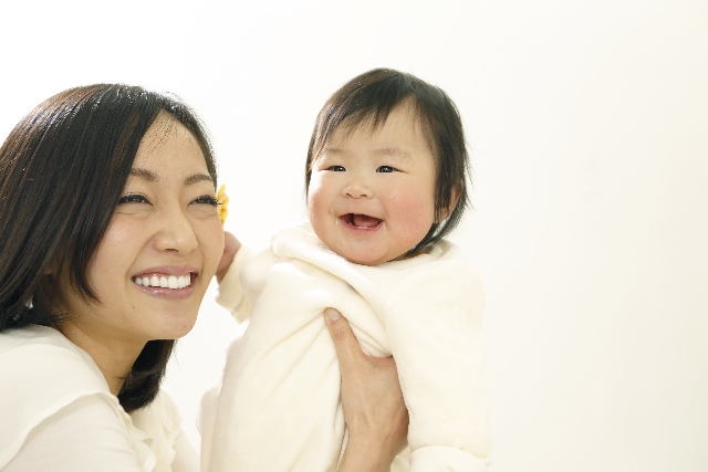 笑顔の赤ちゃんを抱く母親