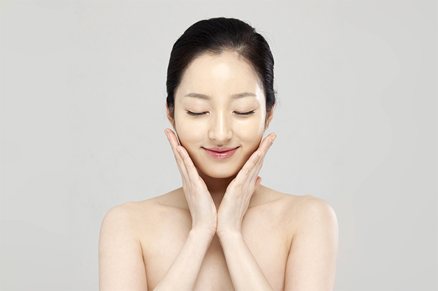 両手を頬に添える女性