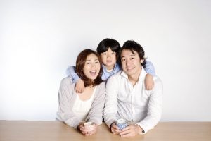 ソファで寄り添い、笑顔を見せる家族